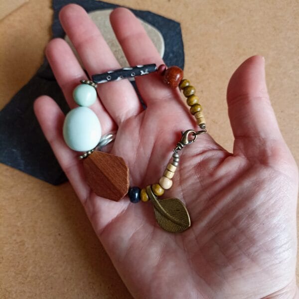 Bracelet en perles vert pâle, bois, métal et verre.