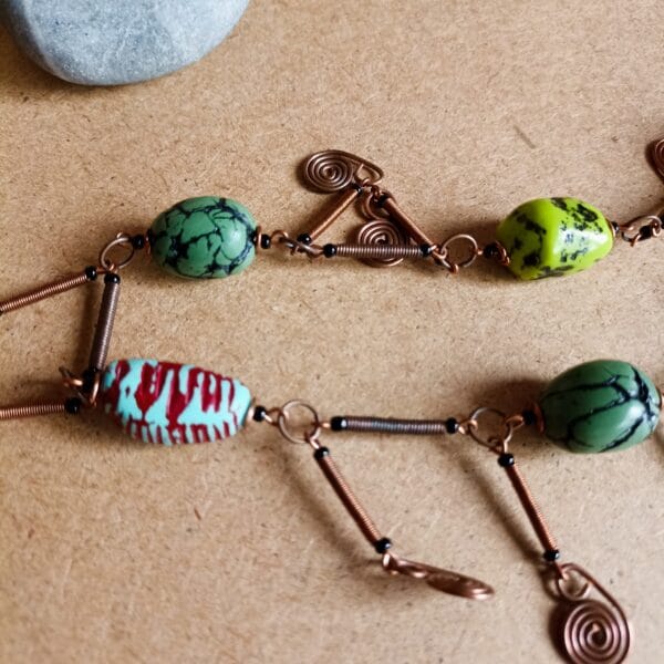 Collier de perles vertes, éléments décoratifs en cuivre.