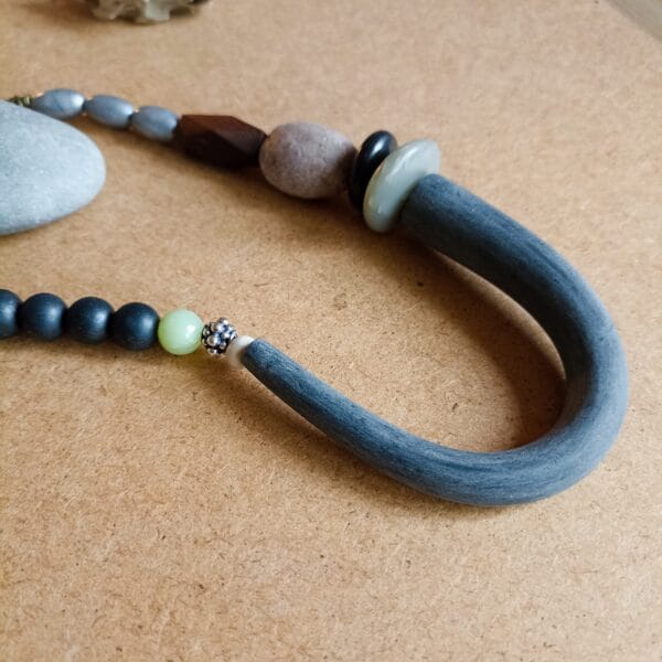 Collier en perles noires, argentées et marron.