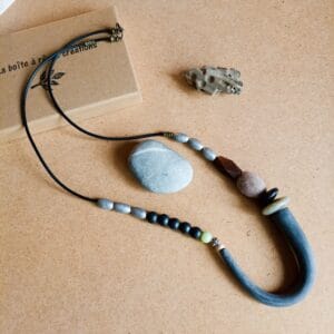 Collier long en perles noires, argentées et marron.