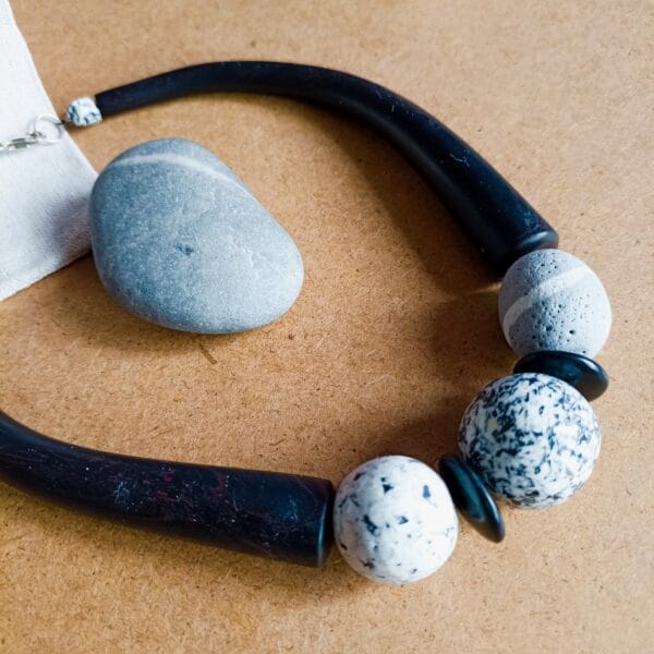 Collier court en perles grises et blanches, éléments couleur bois, style celtique.
