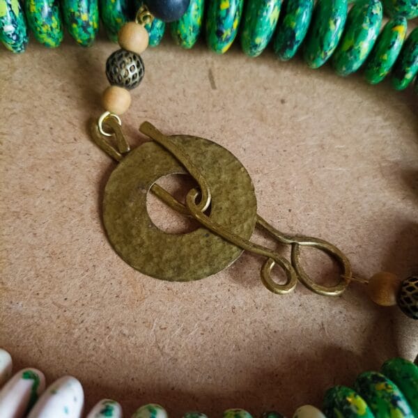 Collier long en perles vertes et blanches, fermoir ouvragé.