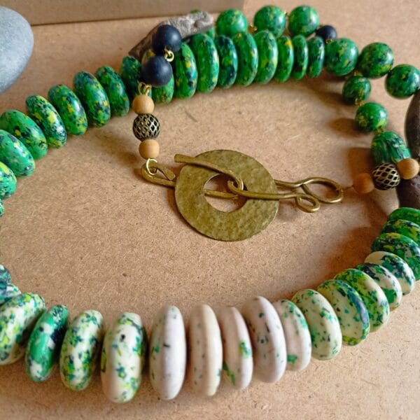 Collier long en perles vertes et blanches, fermoir ouvragé.