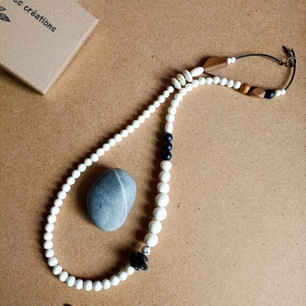 Collier long en perles blanches, noires et bois.