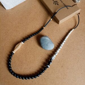 Collier long en perles rondes, noires, blanches et bois.
