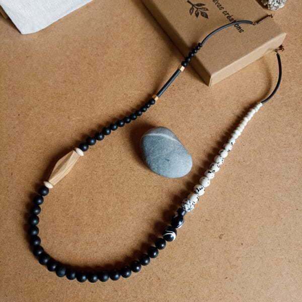 Collier long en perles rondes, noires, blanches et bois.