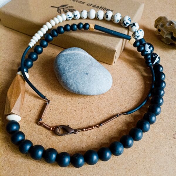 Collier long en perles rondes, noires et blanches, et perles de bois.