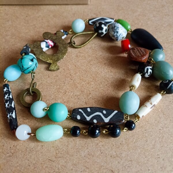 Collier en perles multicolores, noires, vertes, rouge corail et bois.