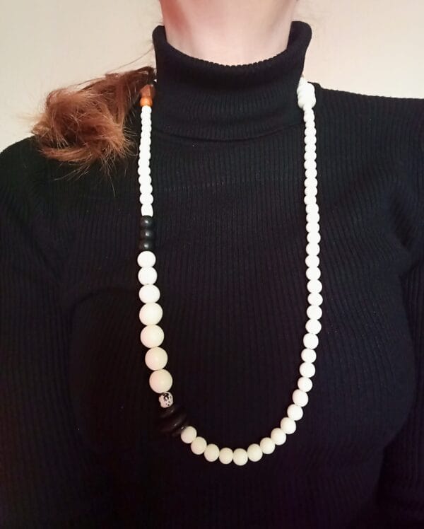 Collier long en perles blanches, noires et bois.
