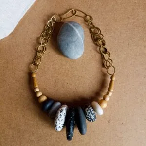 Collier court avec des perles noires, grises et blanches imitant les pierres. Perles en bois et en métal. Pièce unique faite main.
