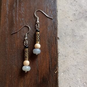 une paire de boucles d'oreilles posée sur un fond en bois brut.
