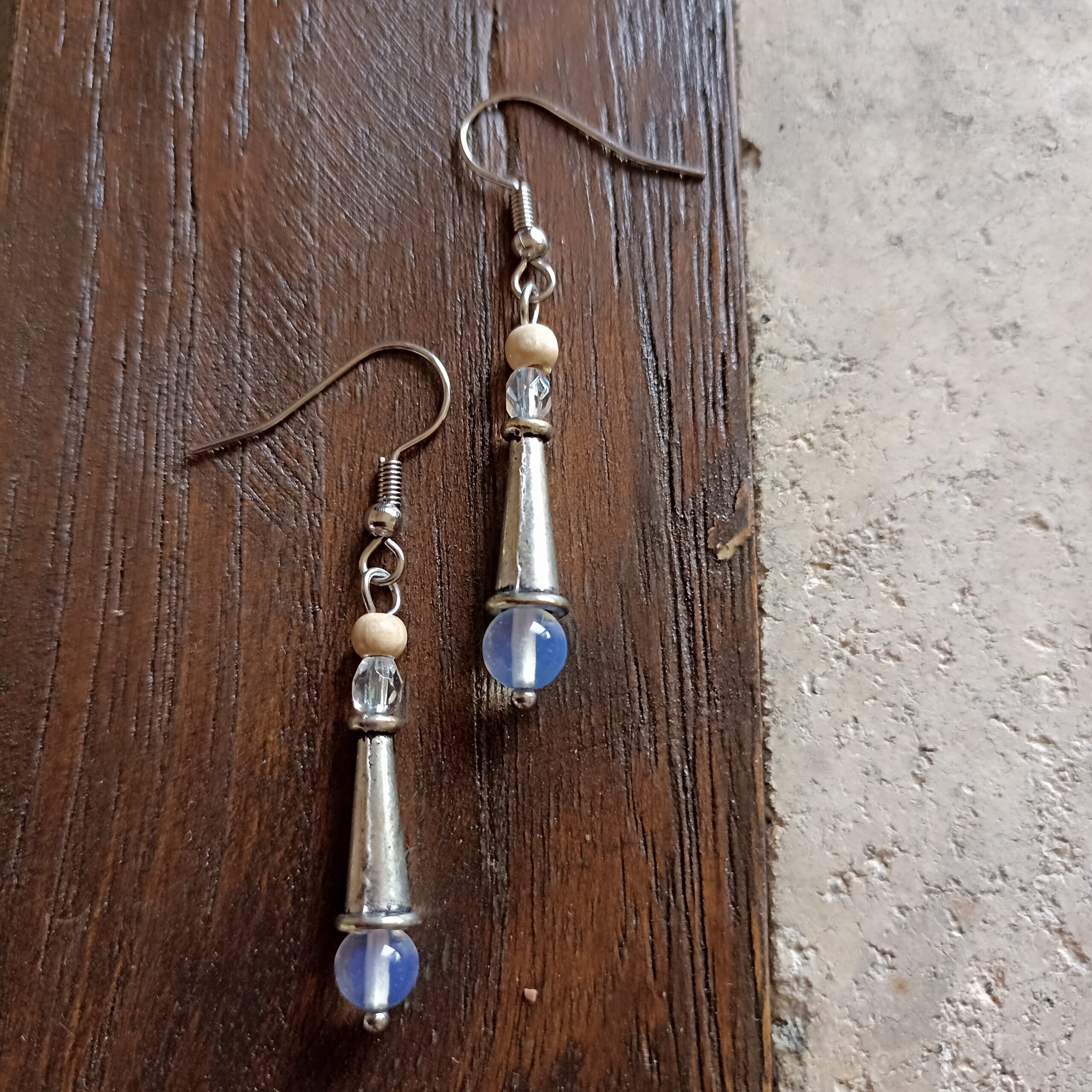 deux boucles d'oreilles en pierre de lune posées sur un fond en bois