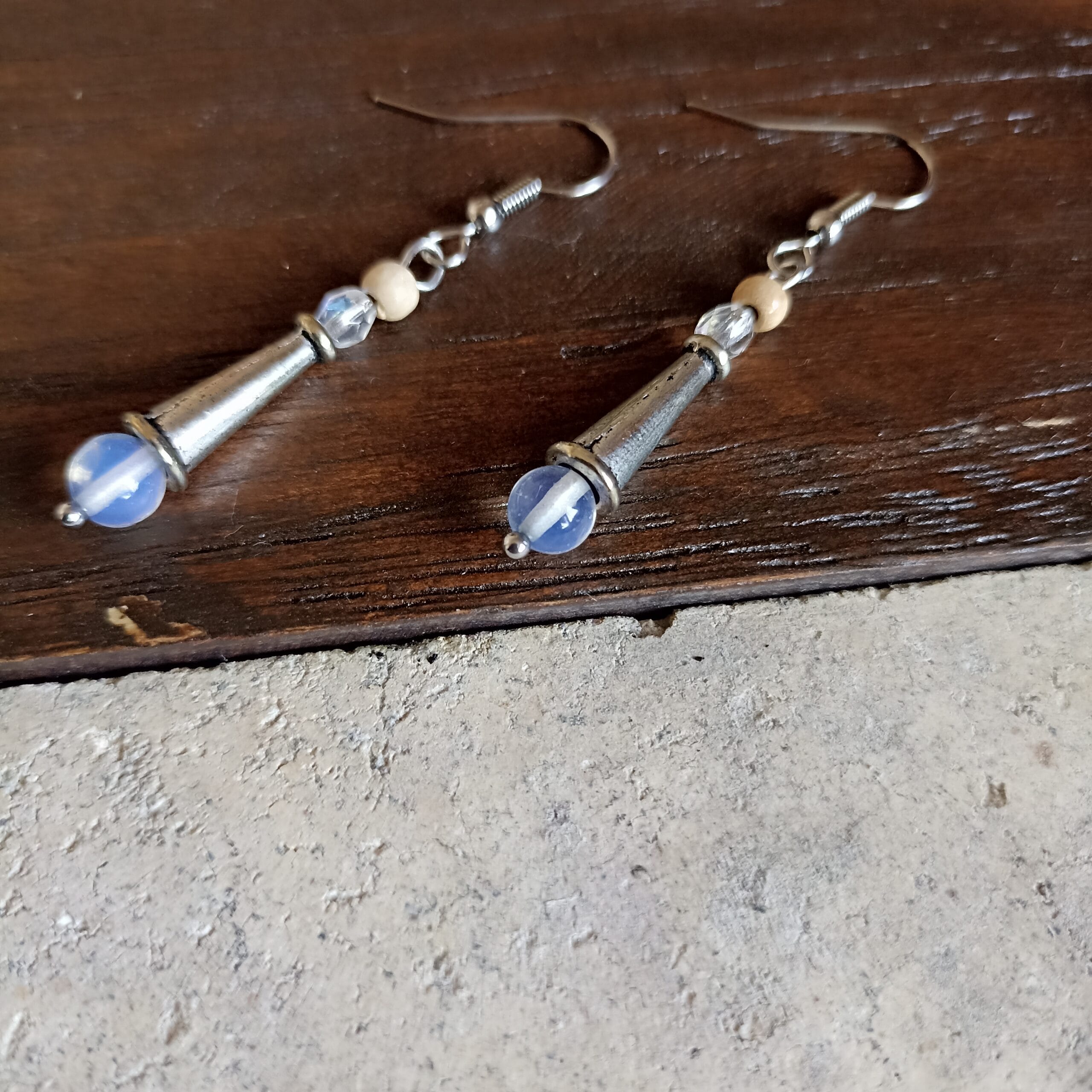 Vue latérale des boucles d'oreilles Lune sur un fond en bois