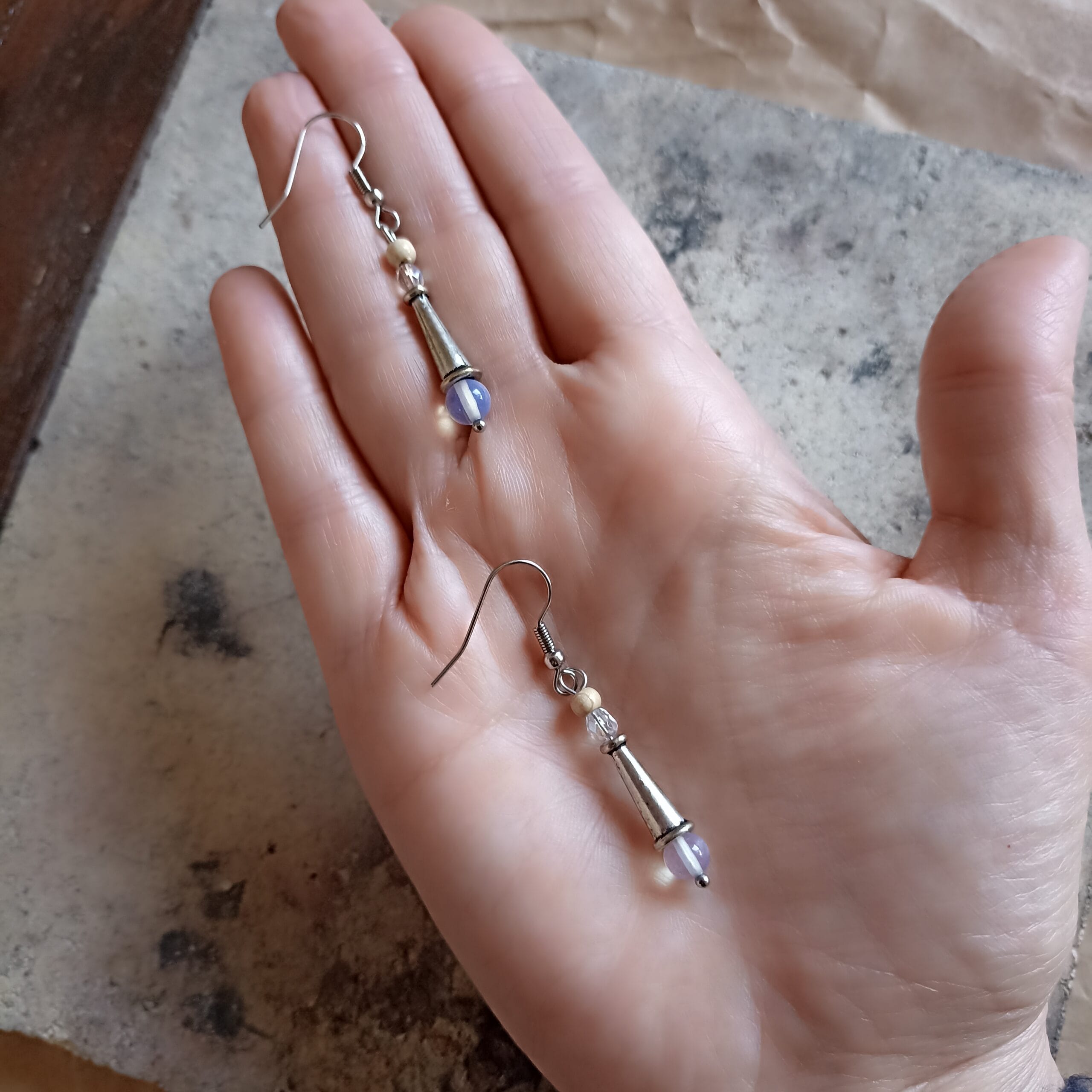 deux boucles d'oreilles en pierre de lune posées dans une main