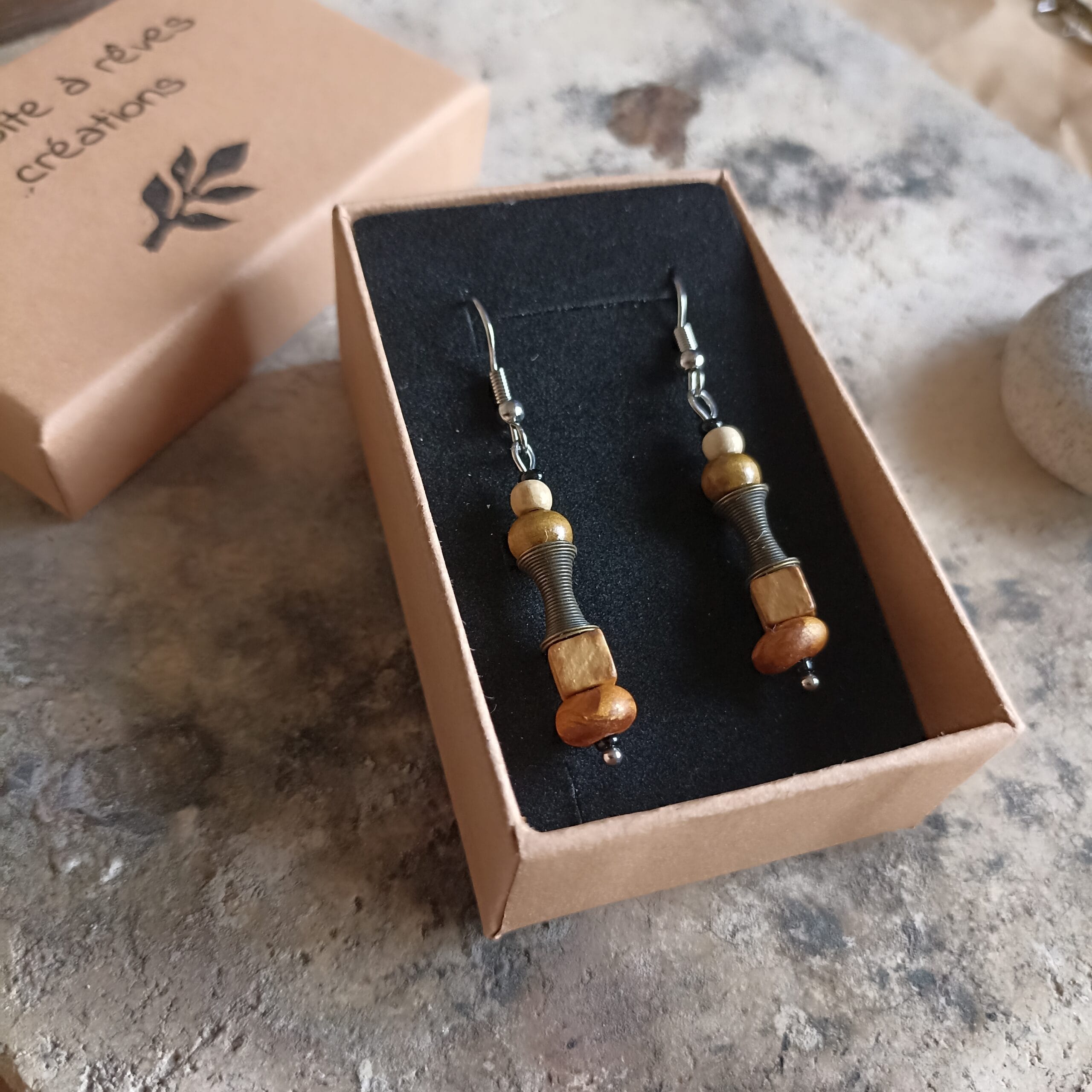 boucles d'oreilles exposées dans leur écrin en carton et velours