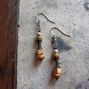 deux boucles d'oreilles posées sur un sol en béton