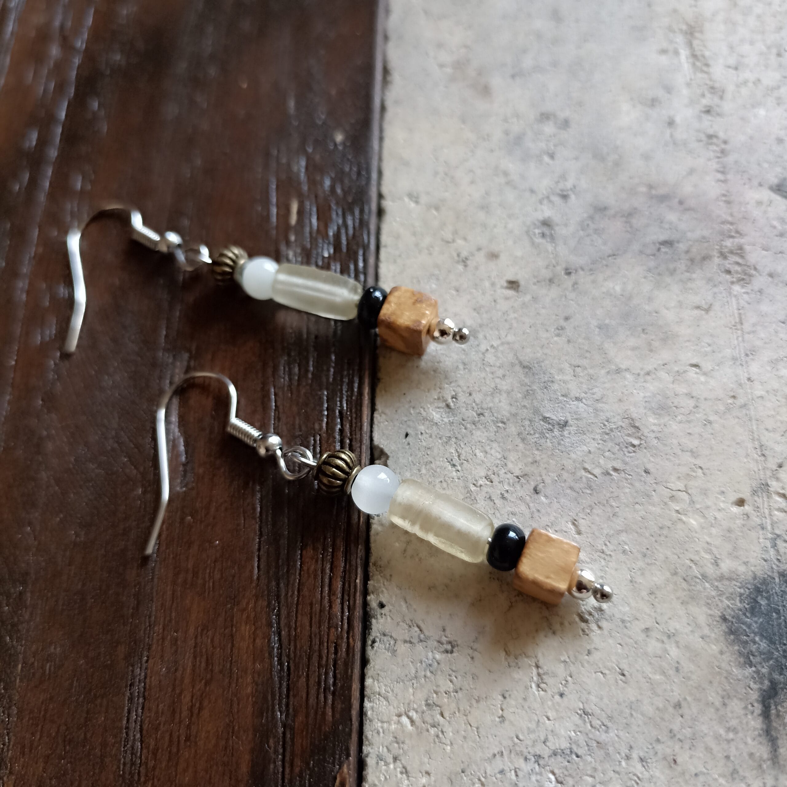 boucles d'oreilles Tamara posées sur un fond en bois et en béton.