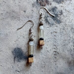 une paire de boucles d'oreilles posée sur un fond en béton.
