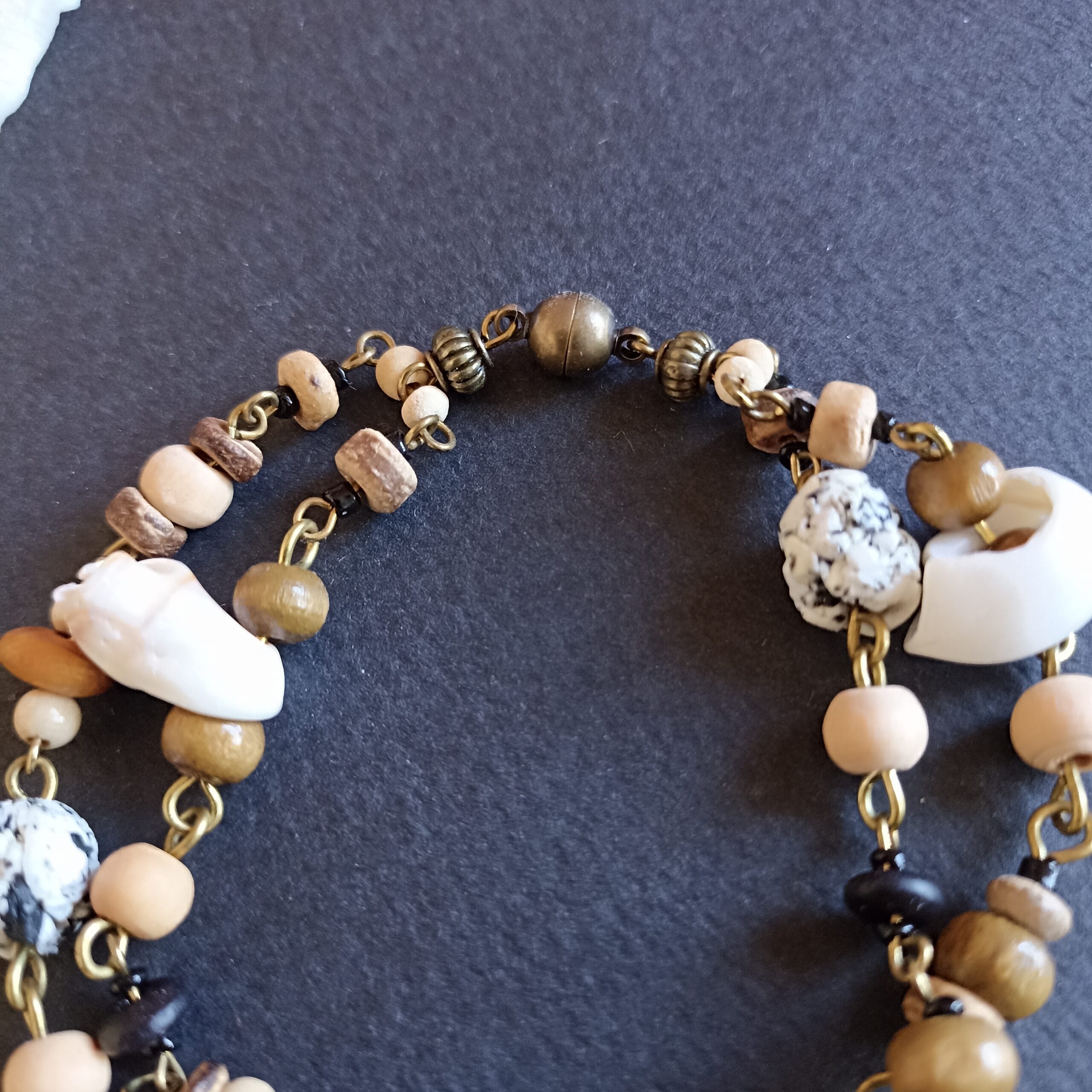 gros plan sur un bracelet aux couleurs de plage, posé sur un fond noir.