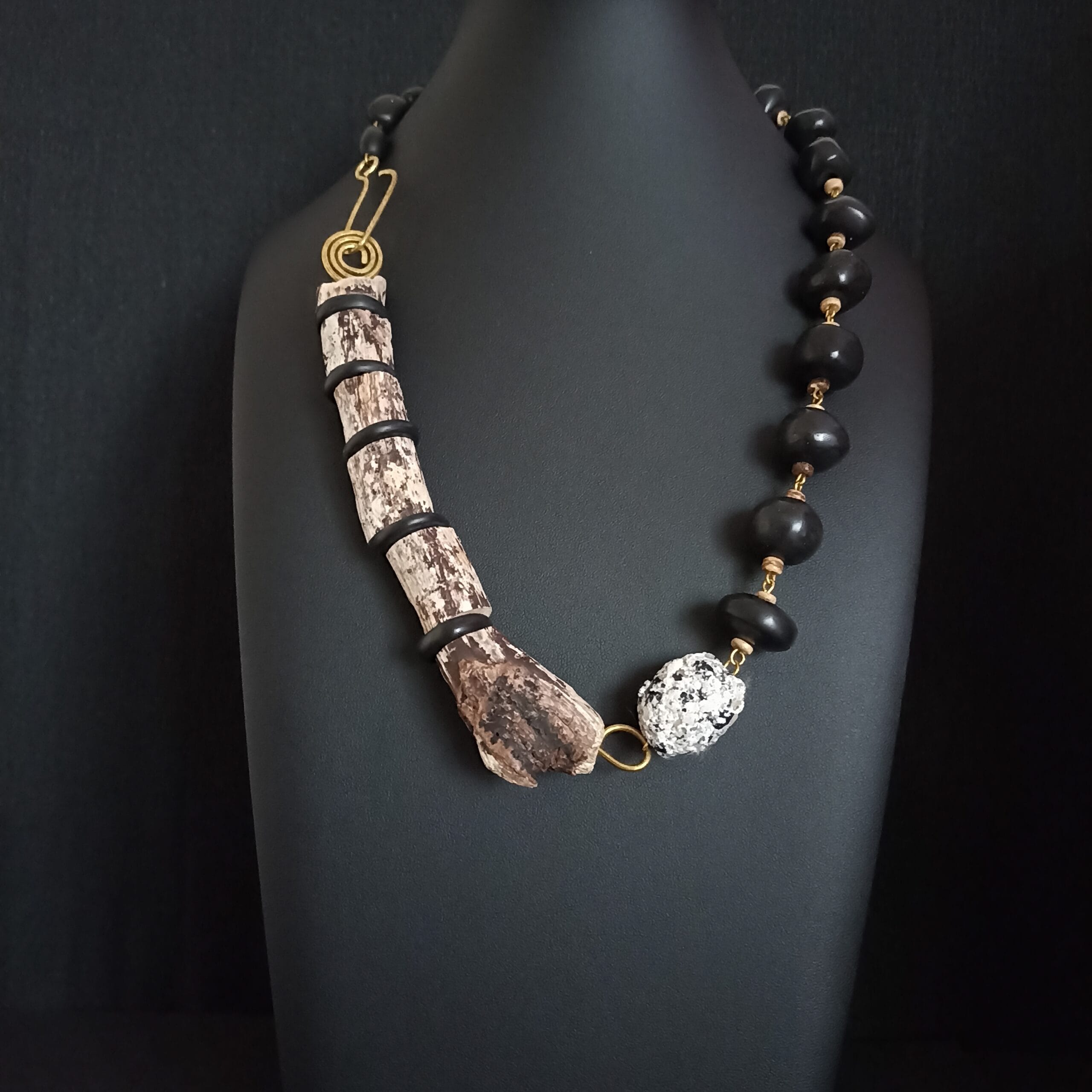 Collier Ecorce en bois flotté et pâte polymère noire posé sur un buste de présentation.