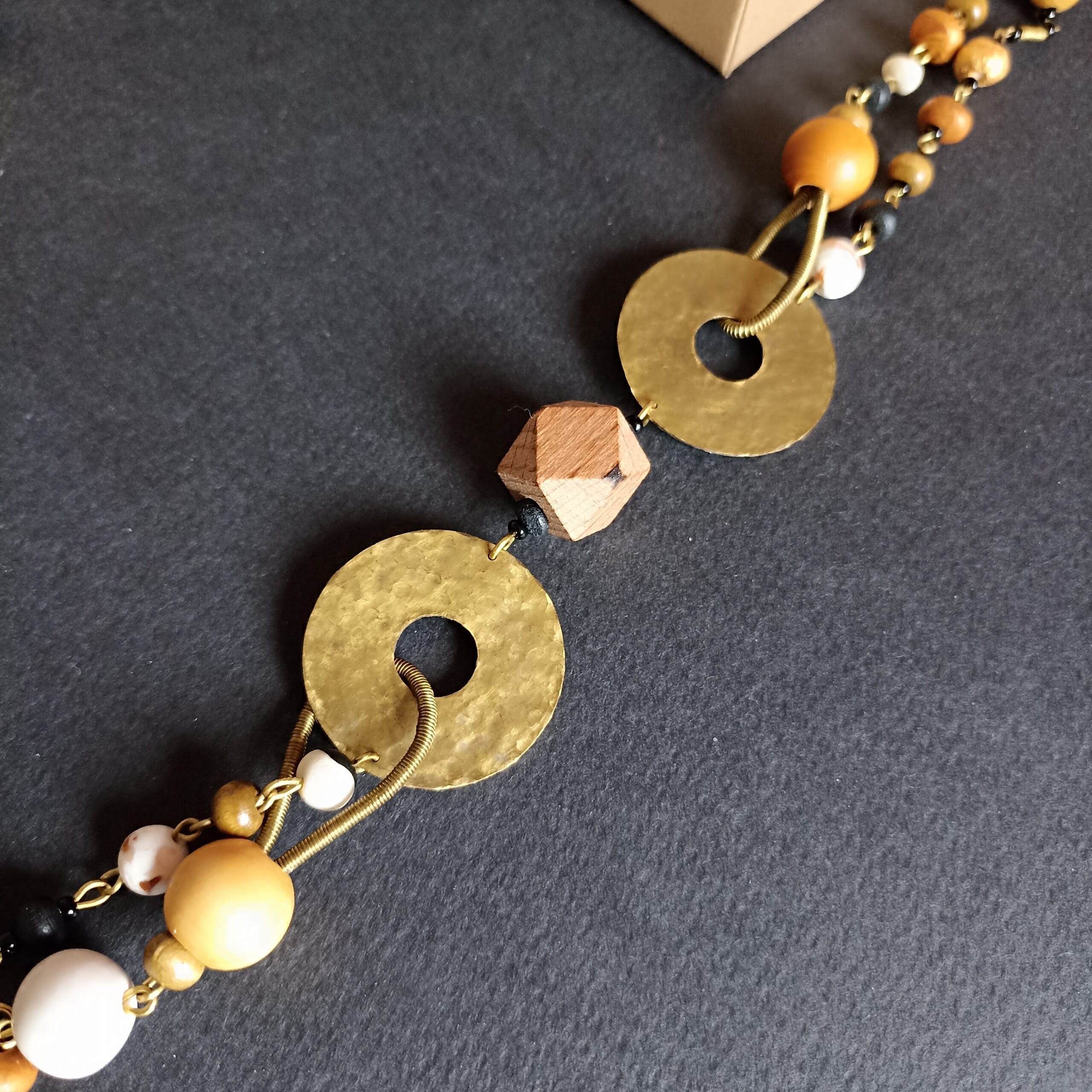 Gros plan sur les éléments en laiton en forme de disque du collier Thétis.