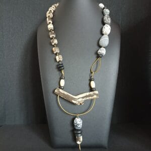 Collier long en bois flotté posé sur son support de présentation.