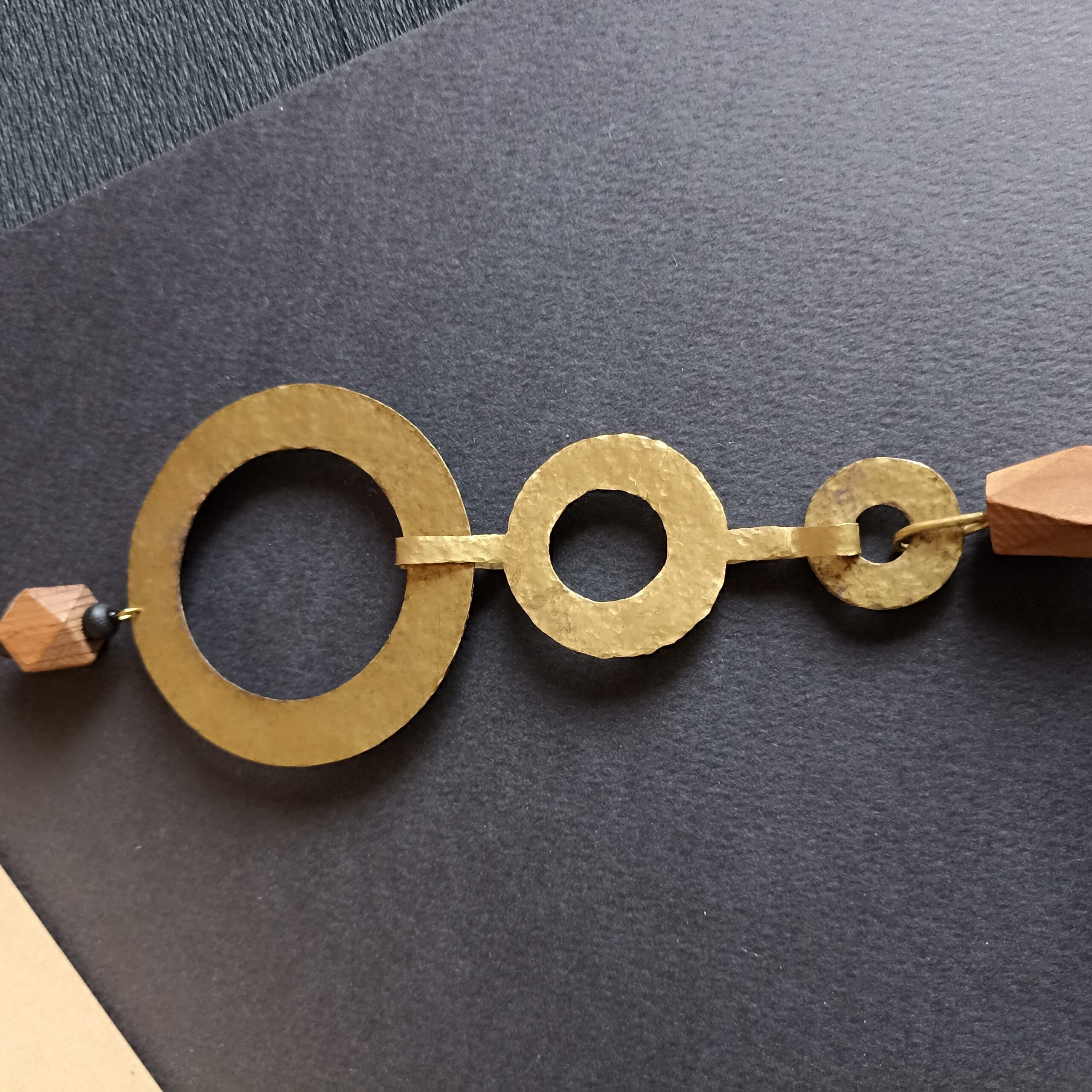 Gros plan sur le fermoir en laiton martelé du collier Océane.