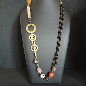 Collier Naïade en perles de verre noir, bois flotté et polymère, sur un buste de présentation.