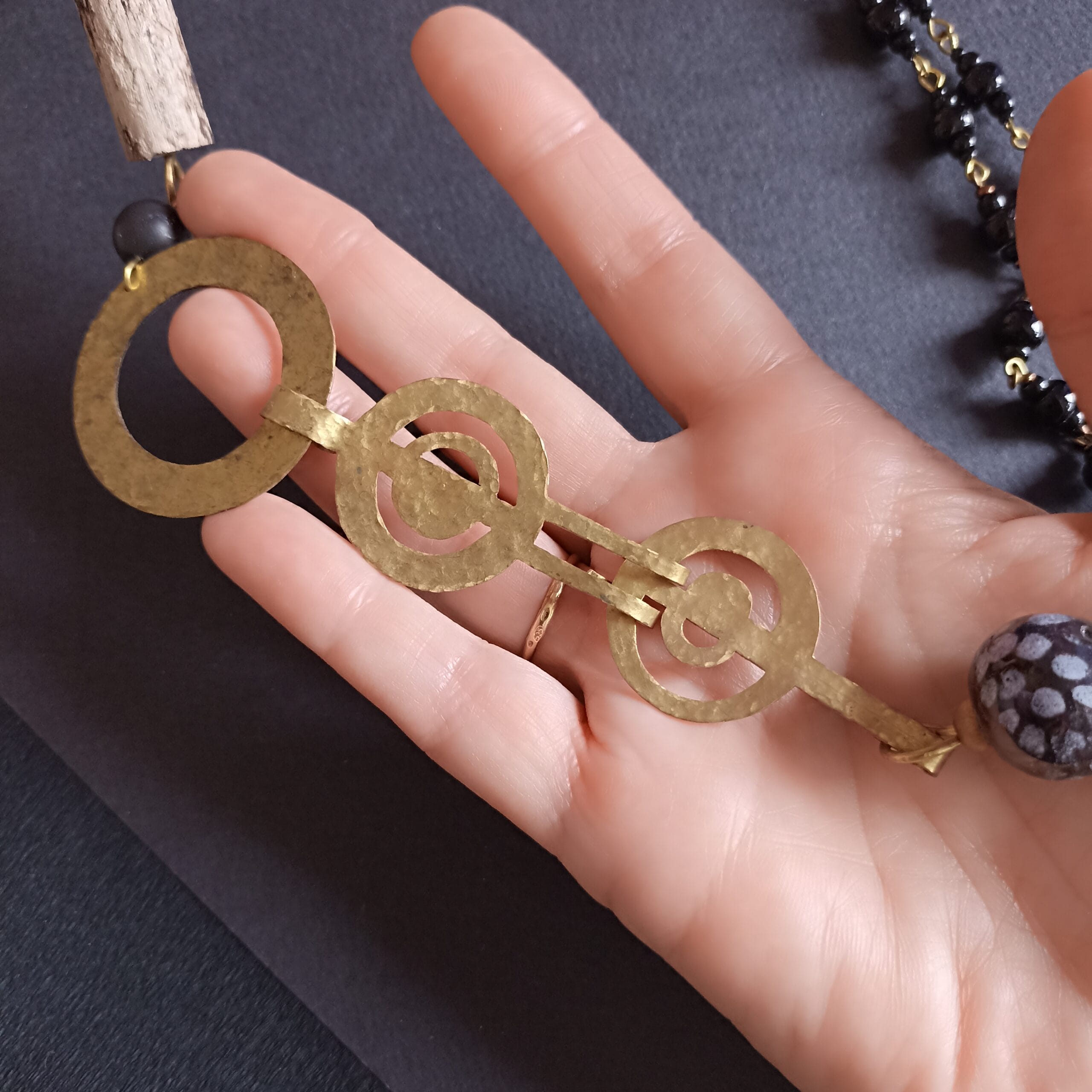 Fermoir du collier Naïade posé dans une main.