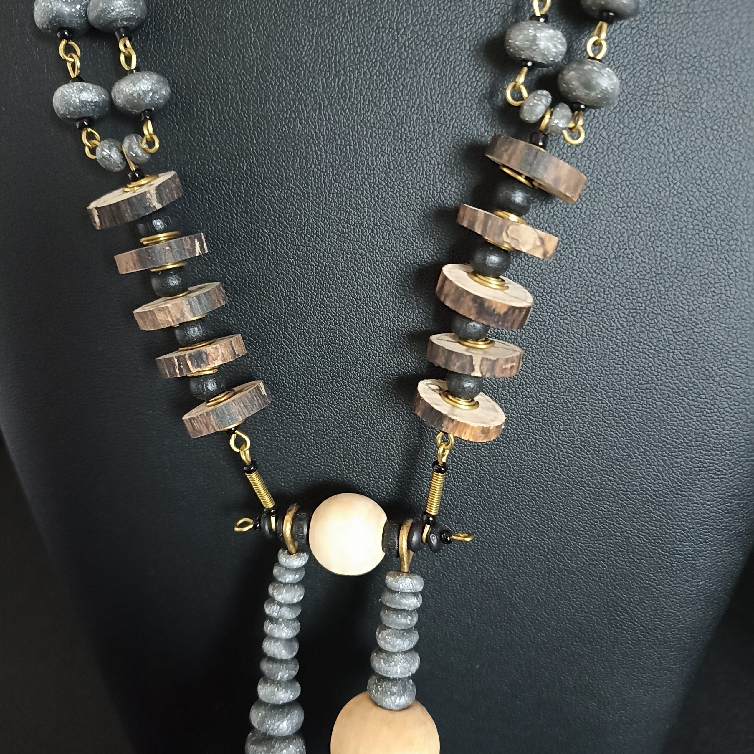 Détail d'un collier composé de rondelles de bois flotté.