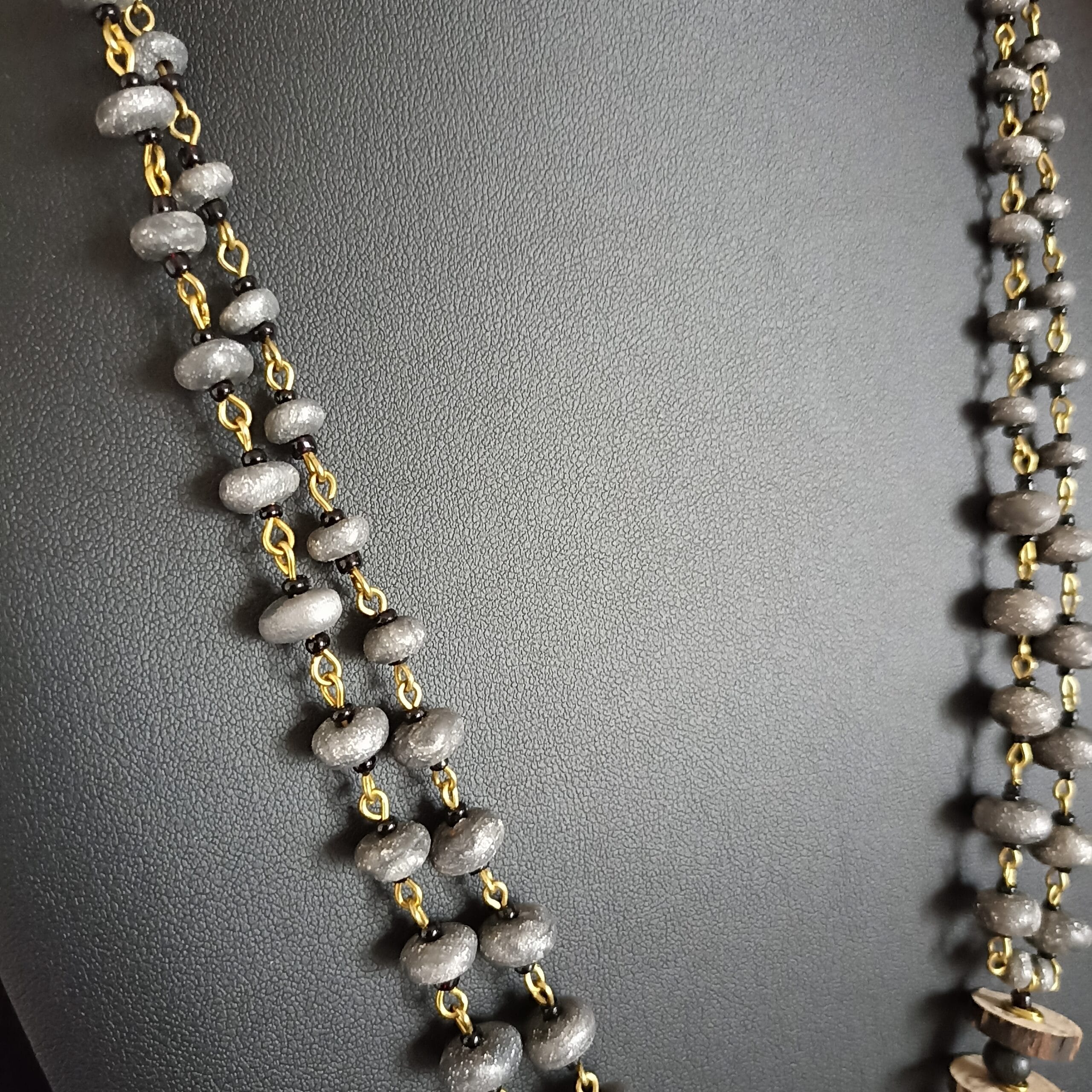 Gros plan sur la chaîne du collier Cairn, avec ses petites perles grises.