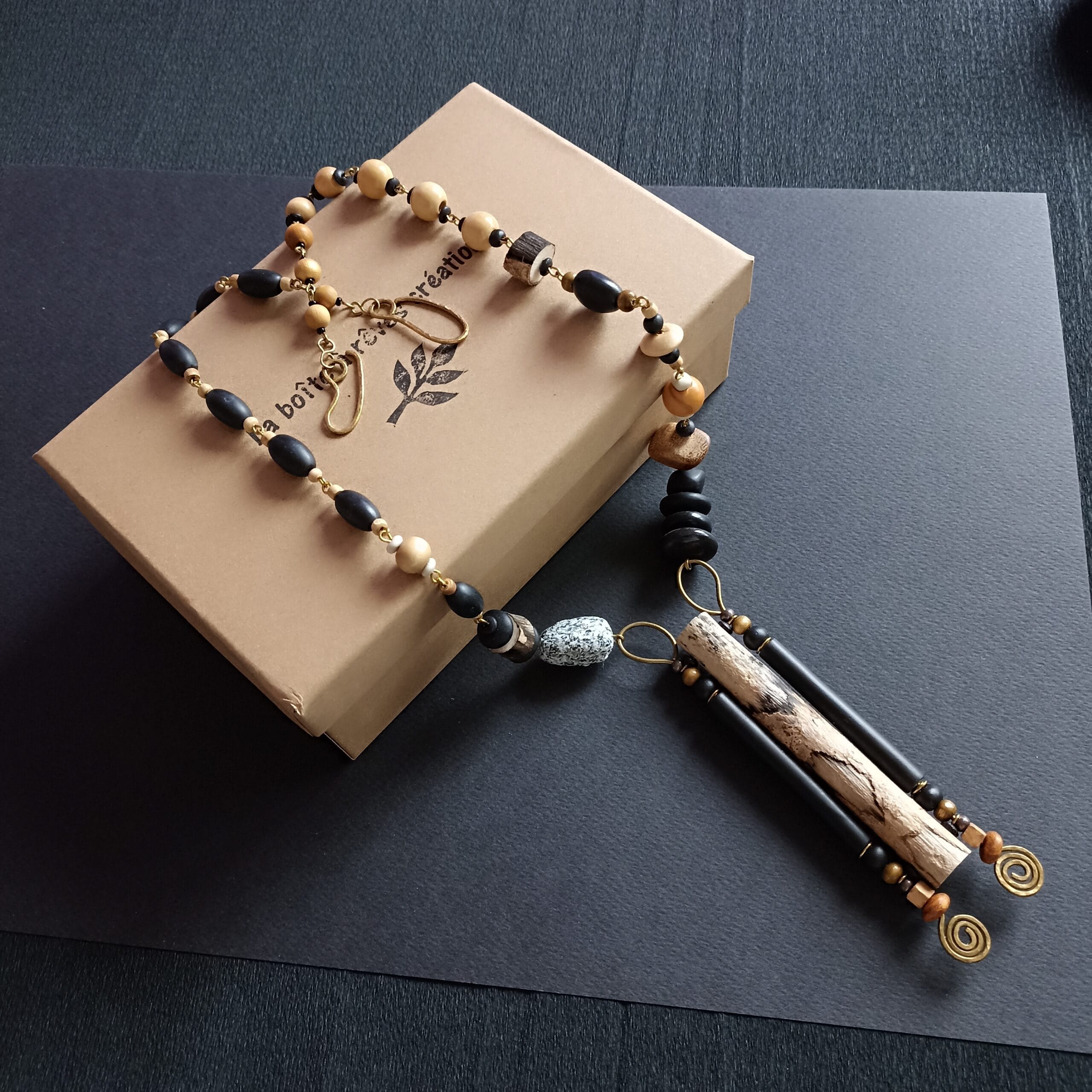 collier Rivage posé sur son écrin sur fond noir.