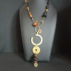 Collier long en perles de bois et polymère, gros pendentif rond en laiton martelé.
