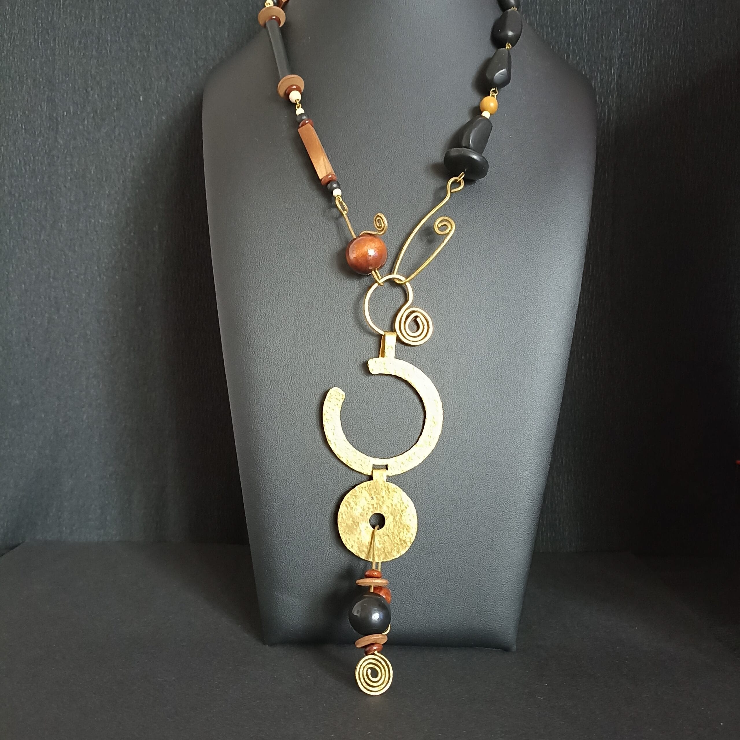 Collier long en perles de bois et polymère, gros pendentif rond en laiton martelé.