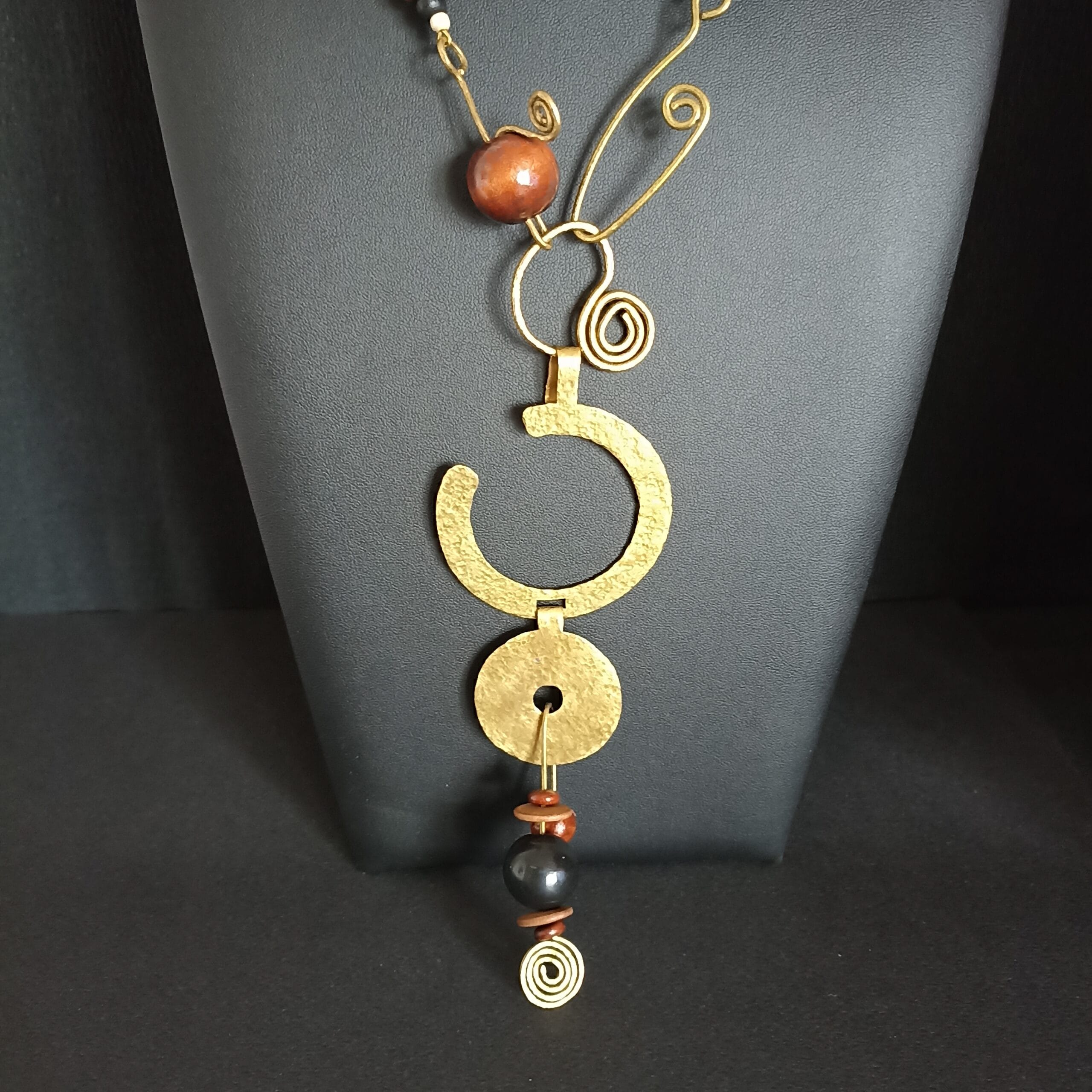 Gros plan sur le pendentif en laiton du collier Abysse.