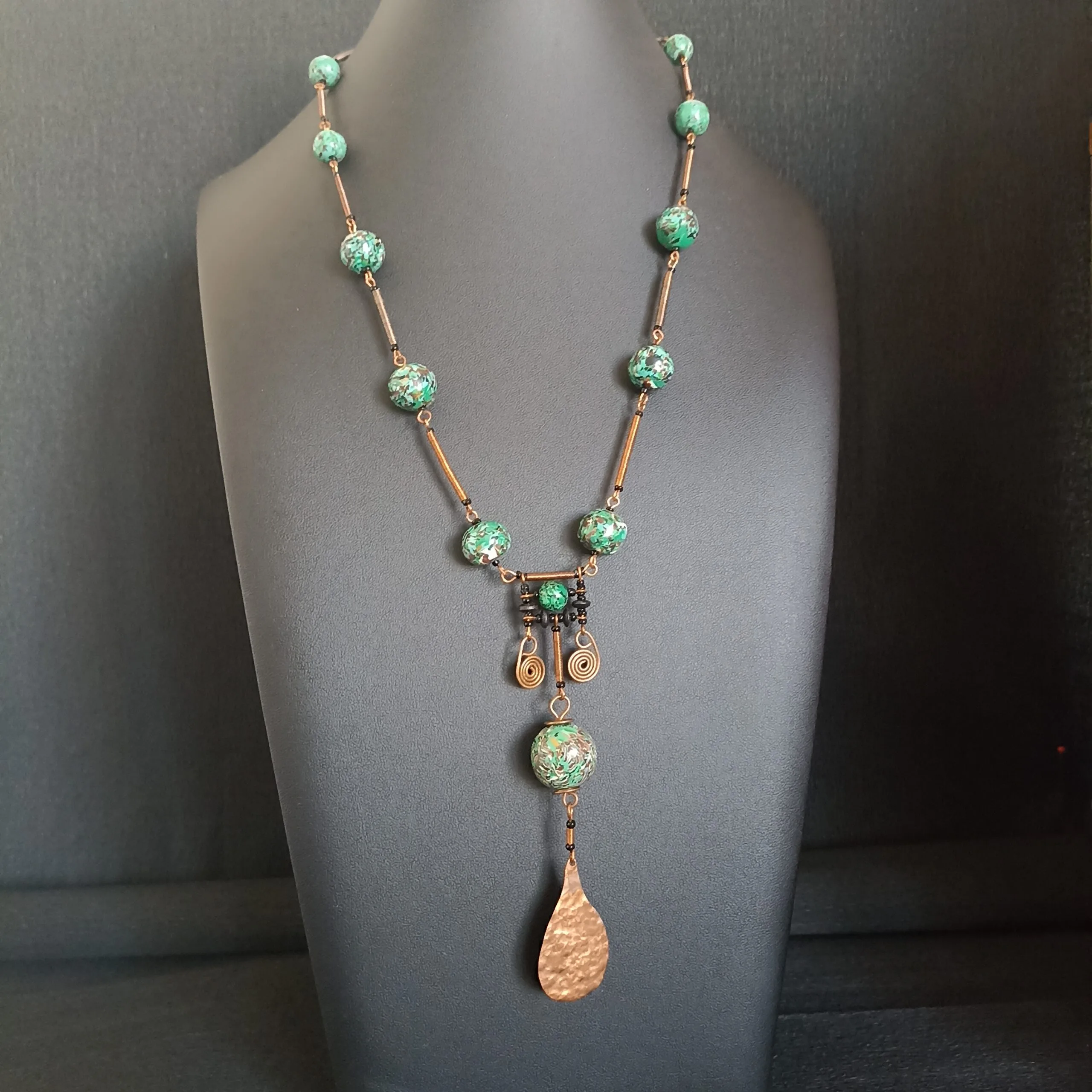 Collier long en perles vertes, rondes et éléments en cuivre martelé.