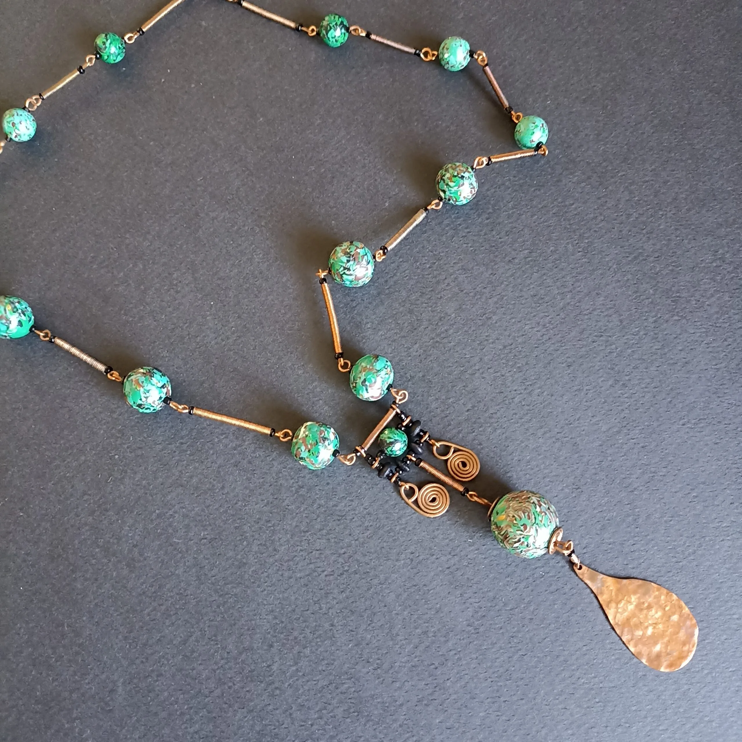 Collier rivière de couleur verte posé sur un fond noir.